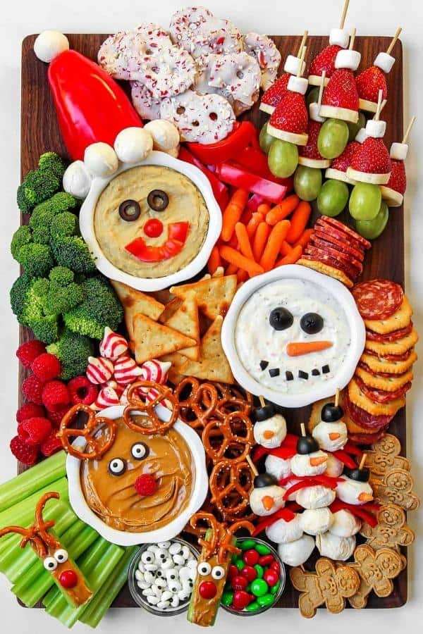 Holiday kids charcuterie board with festive dips, fruit skewers, pretzels and cookies